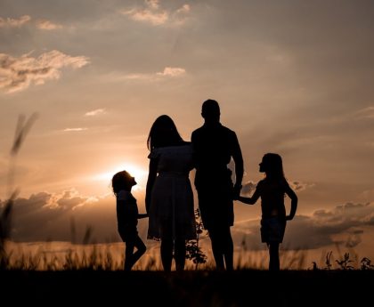 a family standing in a field at sunset